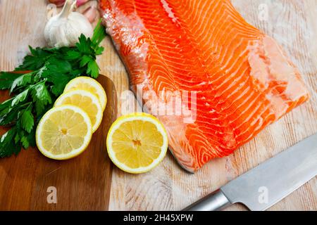 Filet de saumon frais cru sur une table en bois Banque D'Images