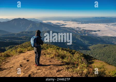 Homme randonnée regardant la chaîne de montagnes au sommet de la montagne dans la forêt tropicale, concept de voyage aventure en plein air Banque D'Images