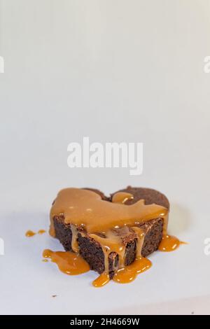 Gâteau au chocolat en forme de cœur avec une délicieuse sauce caramel Banque D'Images