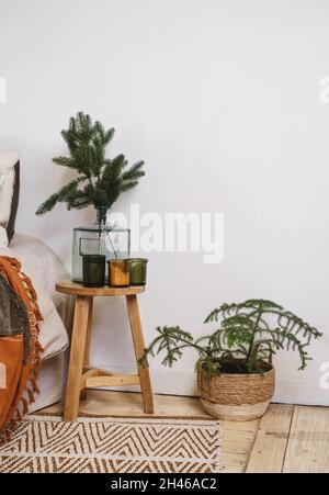 Salon décoration de Noël près du lit dans le style écologique, éléments naturels et sapin véritable en pot et branches en vase.Stile scandinave, copie rustique Banque D'Images