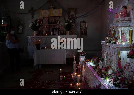 Puebla, Mexique.31 octobre 2021.Au cours du festival du jour des morts, des offrandes monumentales sont établies année après année à Huaquechula, une des communautés distinguées en servant d'autel aux habitants de la ville qui sont morts l'année dernière.Les offres consistent en nourriture et boissons qui conviennent aux goûts de la personne décédée.De plus, des bougies, des fleurs, des images religieuses et la photo du défunt sont placées.Crédit : Jacky Muniello/dpa/Alay Live News Banque D'Images