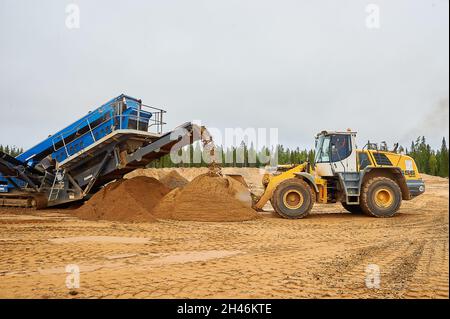 Le chargeur frontal de la carrière recueille un godet de sable Banque D'Images