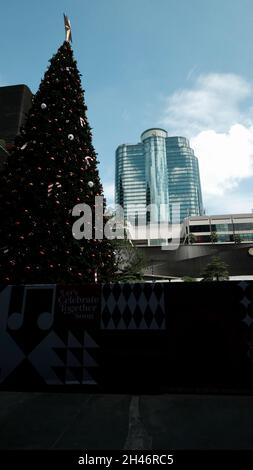 Arbre de Noël long et haut en haut Central World Mall Pathum WAN Bangkok Thaïlande avec President Towers Skyscraper en arrière-plan Banque D'Images