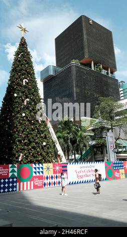 Arbre de Noël long et haut en haut Central World Mall Pathum WAN Bangkok Thaïlande avec President Towers Skyscraper en arrière-plan Banque D'Images