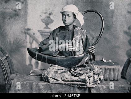 Un garçon jouant un saung ou une harpe birmane.Traiter l'impression. Banque D'Images