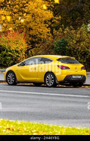 Moscou; Russie - 15 octobre; 2021: Yellow Opel Astra est garée dans la rue lors d'une journée chaude avec la toile de fond du parc d'automne Banque D'Images