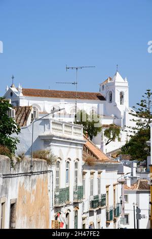 Bâtiments le long de la Rua Tenente Couto, dans la vieille ville avec l'église Santa Maria à l'arrière, Tavira, Algarve, Portugal, Europe. Banque D'Images