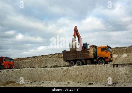 Une pelle hydraulique charge un camion-citerne de sable pour les travaux de construction sur l'autoroute fédérale Don reliant les villes de Moscou, Voronezh, Rostov-on-Don, Krasnodar et Novorossiysk.La longueur de la route est de 1543 km Banque D'Images