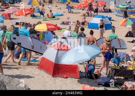 La chaleur intense et le soleil permanent font sortir la foule des vacanciers sur la plage de Fistral à Newquay, dans les Cornouailles. Banque D'Images