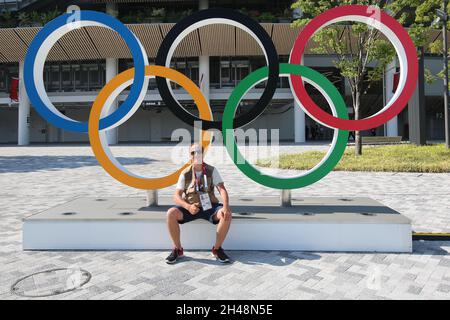 23 JUILLET 2021 - TOKYO, JAPON: Photographe officiel Mickael CHAVET devant les anneaux olympiques au Stade National du Japon devant le Tokyo 2 Banque D'Images