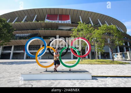 23 JUILLET 2021 - TOKYO, JAPON: Photographe officiel Mickael CHAVET devant les anneaux olympiques au Stade National du Japon devant le Tokyo 20 Banque D'Images