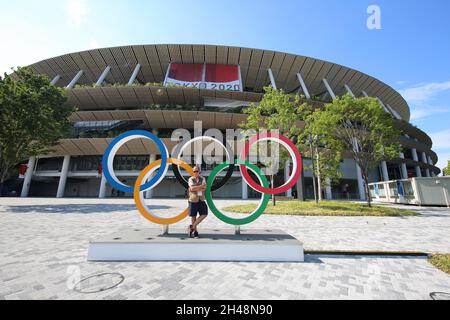 23 JUILLET 2021 - TOKYO, JAPON: Photographe officiel Mickael CHAVET devant les anneaux olympiques au Stade National du Japon devant le Tokyo 20 Banque D'Images