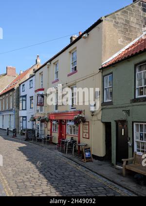 La grande rue principale avec des boutiques et des pubs dans le village de bord de mer de Staithes, dans le quartier de Scarborough, dans le North Yorkshire, en Angleterre. Banque D'Images