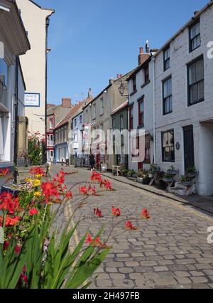 La grande rue principale avec des boutiques et des pubs dans le village de bord de mer de Staithes, dans le quartier de Scarborough, dans le North Yorkshire, en Angleterre. Banque D'Images