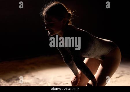 Vue latérale Portrait de la jeune femme caucasienne danseuse de ballet ayant le repos, lady après Ballet performance, prenant Une pause.Belle dame en Bodysu Banque D'Images