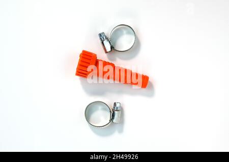 Montage du connecteur et du collier en métal sur fond blanc, vue de dessus.Raccord en plastique orange pour tuyau d'arrosage.Raccord de flexible en plastique et acier galvanisé Banque D'Images