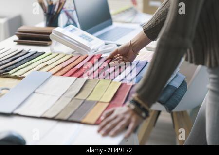 Décorateur professionnel travaillant dans son studio, elle choisit des nuances de tissu pour son projet Banque D'Images