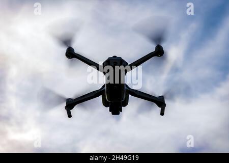 silhouette de drone volant sur fond ciel sombre et nuageux Banque D'Images