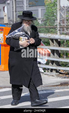 Un juif orthodoxe plus âgé revient des services de synagogue en tenant son sac tallis.Sur Lee Avenue à Williamsburg, Brooklyn, New York. Banque D'Images