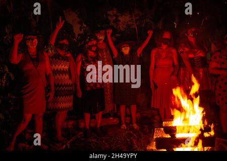 Plusieurs femmes autour d'un feu de camp.La nuit des sorcières rouges - était un événement politique d'Halloween contre le président Jair Bolsonaro. Banque D'Images