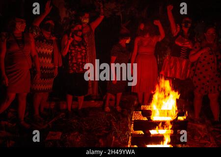 Plusieurs femmes autour d'un feu de camp.La nuit des sorcières rouges - était un événement politique d'Halloween contre le président Jair Bolsonaro. Banque D'Images