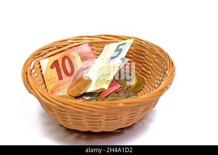 Billets et pièces dans le panier pour la collecte d'argent Banque D'Images