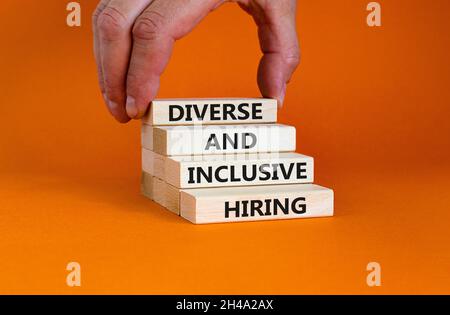 Symbole d'embauche diversifié et inclusif. Blocs en bois avec des mots divers et inclus location sur un magnifique fond orange. Main d'homme d'affaires. Entreprise, Banque D'Images