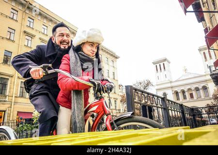 Un couple heureux, amoureux de l'hiver, en plein air sur vélo d'époque - beau hipster homme avec jeune femme s'amusant ensemble Banque D'Images