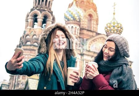 Des amies heureuses prenant un selfie d'hiver à l'église de ' Sauveur sur le sang renversé ' à Saint-Pétersbourg - concept d'amitié avec les filles s'amusant ensemble Banque D'Images