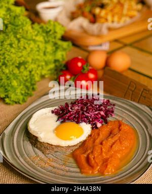 Plat de hachage de bœuf corned avec un œuf croustillant et un chou rouge mariné. Journée ensoleillée Banque D'Images