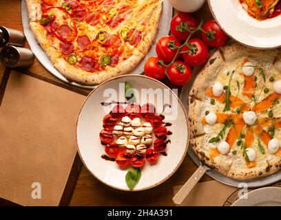 Vue de dessus sur l'énorme buffet de délicieux plats européens fraîchement préparés et pizza avec papier vide pour le menu Banque D'Images