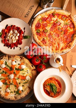 Vue de dessus sur un énorme buffet de délicieux plats européens fraîchement préparés et pizza avec menu Banque D'Images