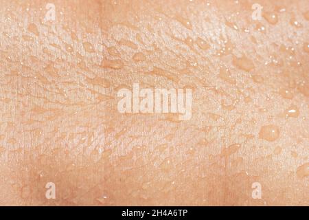 mouillez la peau de la femme avec des gouttes de liquide en gros plan. Banque D'Images