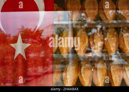Istanbul, Turquie.12 octobre 2021.Pains traditionnels turcs à vendre dans une fenêtre de boulangerie typique à côté d'un drapeau turc.Crédit : SOPA Images Limited/Alamy Live News Banque D'Images