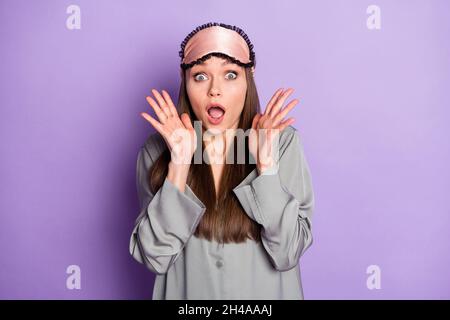 Portrait d'une fille effrayée et attirante portant un pyjama effrayante nouvelles effrayantes réaction isolée sur fond violet violet couleur violet Banque D'Images