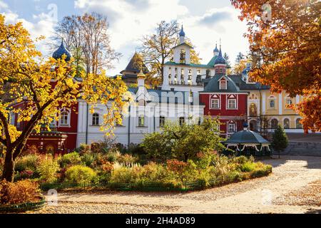 Monastère Pskov-Pechersky en automne avec des arbres jaune et orange lumineux illuminant au soleil.Région de Pskov, Russie Banque D'Images