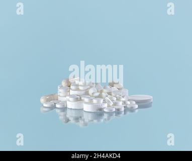 Un tas de pilules blanches de montagnes sur un fond bleu. Banque D'Images