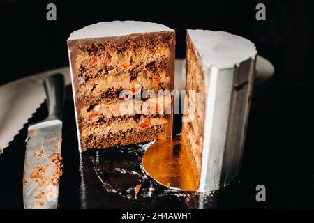 Des gâteaux incroyables.Gâteau de mariage en tranches de chocolat avec garniture étonnante sur fond noir. Grand gâteau au chocolat blanc. Banque D'Images