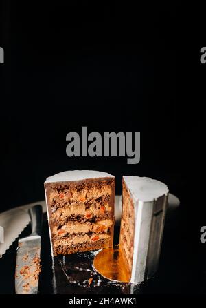 Des gâteaux incroyables.Gâteau de mariage en tranches de chocolat avec garniture étonnante sur fond noir. Grand gâteau au chocolat blanc. Banque D'Images