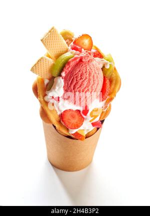 Crème glacée à base de gaufres avec fruits frais et baies sur fond blanc Banque D'Images