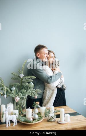 L'homme embrasse sa femme enceinte. Elle tient le chat mignon entre les mains. Banque D'Images