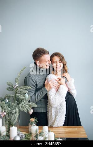 L'homme embrasse sa femme enceinte. Elle se hante la main sur son sourire. Banque D'Images