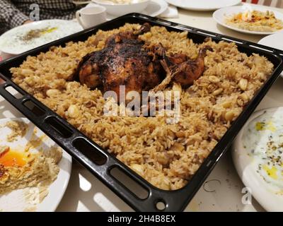 Poulet rôti sur du riz cuit dans un plateau de cuisson carré noir. Mise au point sélective Banque D'Images