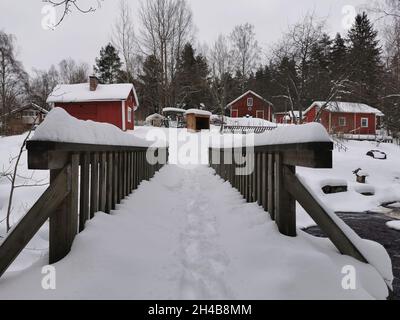 Chalets en bois rouge dans une forêt.Météo enneigée. Banque D'Images
