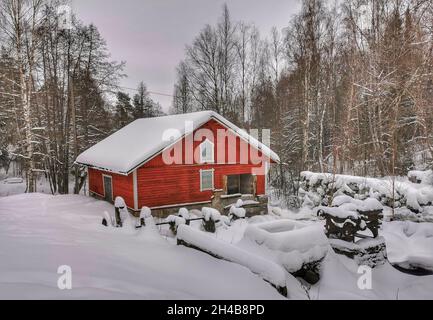 Chalets en bois rouge dans une forêt.Météo enneigée. Banque D'Images