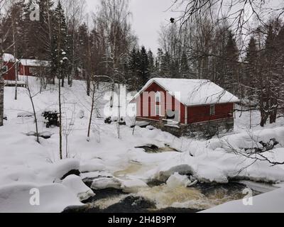 Chalets en bois rouge dans une forêt.Météo enneigée. Banque D'Images