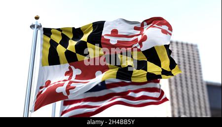 Le drapeau de l'état américain du Maryland agitant dans le vent avec le drapeau américain flou dans l'arrière-plan.Le drapeau est la bannière héraldique du XVIIe siècle Banque D'Images