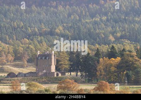 Le château de Braemar, dans les Highlands d'Écosse, se trouve au milieu de la forêt lors d'une matinée d'automne ensoleillée Banque D'Images