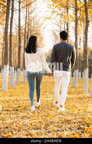 De jeunes amoureux heureux marchant dans les bois Banque D'Images
