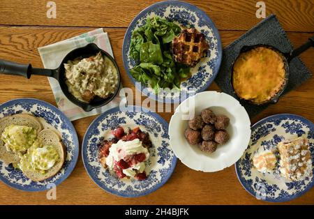 Food Story, brunch authentique de la cuisine du Sud, sauce à la saucisse avec poêle en fonte, gaufres, quiche et petits gâteaux, table à manger avec vue sur le dessus Banque D'Images